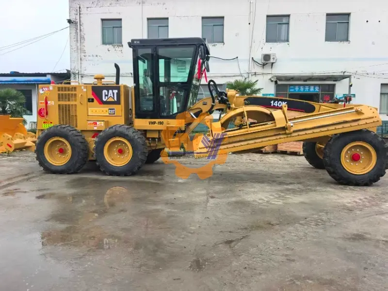 Cat 140K motor grader performing precise grading work on a road construction site.